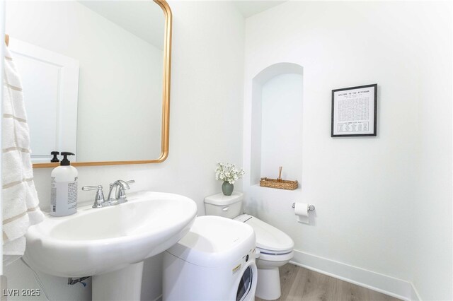 7307 Grace Estate Ave, Las Vegas, NV 89113 - bathroom featuring wood finished floors, toilet, baseboards, and a sink