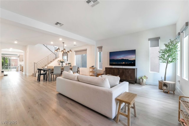 7307 Grace Estate Ave, Las Vegas, NV 89113 - living room with arched walkways, light wood-style floors, visible vents, and stairs