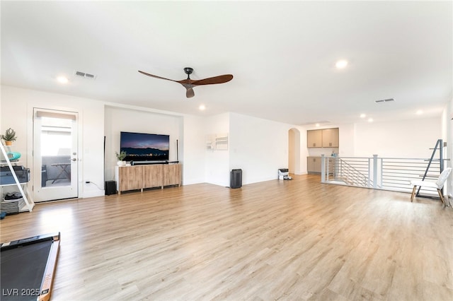 7307 Grace Estate Ave, Las Vegas, NV 89113 - unfurnished living room with arched walkways, light wood-type flooring, visible vents, and ceiling fan