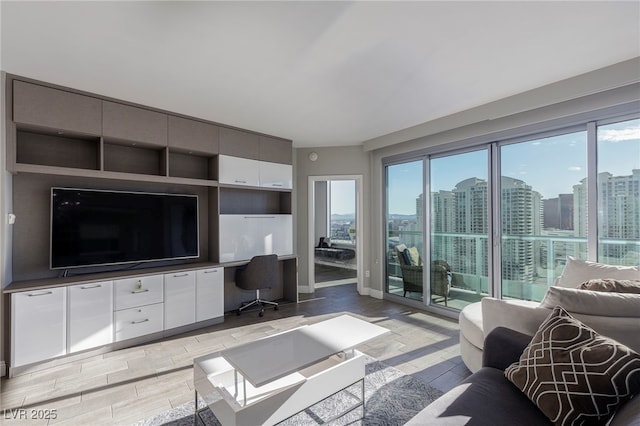 living room with a wealth of natural light, a city view, and light wood-type flooring