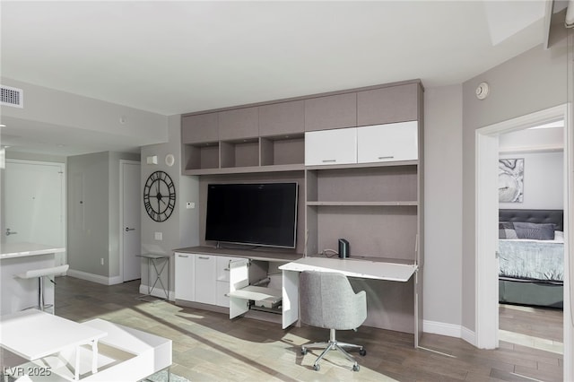 home office featuring light wood-type flooring, visible vents, and baseboards