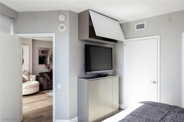 bedroom featuring visible vents, wood finished floors, and baseboards