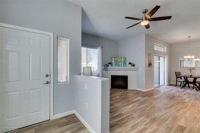 2305 W Horizon Ridge Pkwy Unit 3713, Henderson, NV 89052 - foyer featuring light wood-type flooring, baseboards, a fireplace, and ceiling fan with notable chandelier