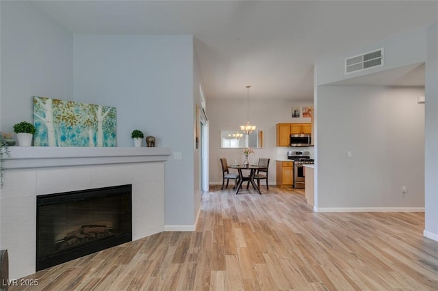 2305 W Horizon Ridge Pkwy Unit 3713, Henderson, NV 89052 - living room with a tile fireplace, visible vents, light wood-type flooring, baseboards, and a notable chandelier