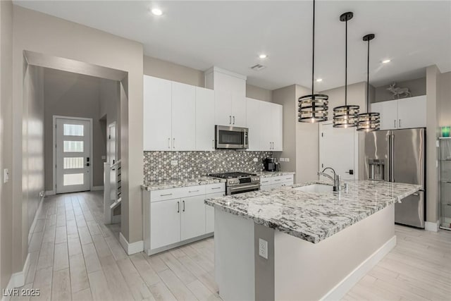 3208 Lumassina Way, Henderson, NV 89044 - kitchen with tasteful backsplash, premium appliances, a sink, light wood-style flooring, and baseboards