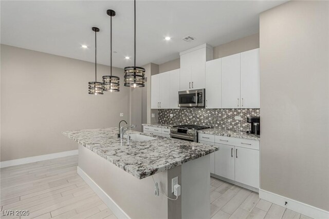 3208 Lumassina Way, Henderson, NV 89044 - kitchen with a sink, a kitchen island with sink, stainless steel appliances, backsplash, and visible vents