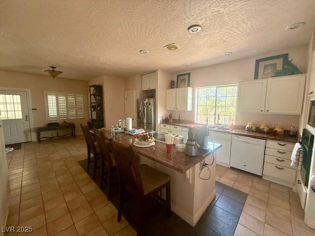 10561 Rancho Destino Rd, Las Vegas, NV 89183 - kitchen with white appliances, a textured ceiling, and a wealth of natural light