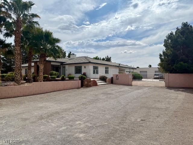 10561 Rancho Destino Rd, Las Vegas, NV 89183 - rear view of property featuring a gate, fence, and a chimney
