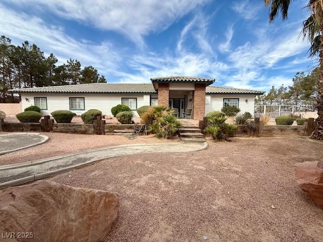 10561 Rancho Destino Rd, Las Vegas, NV 89183 - view of front of home with fence and a tiled roof