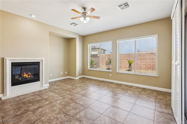 3904 Redbreast Ln, North Las Vegas, NV 89084 - unfurnished living room featuring a glass covered fireplace, visible vents, a ceiling fan, and tile patterned floors