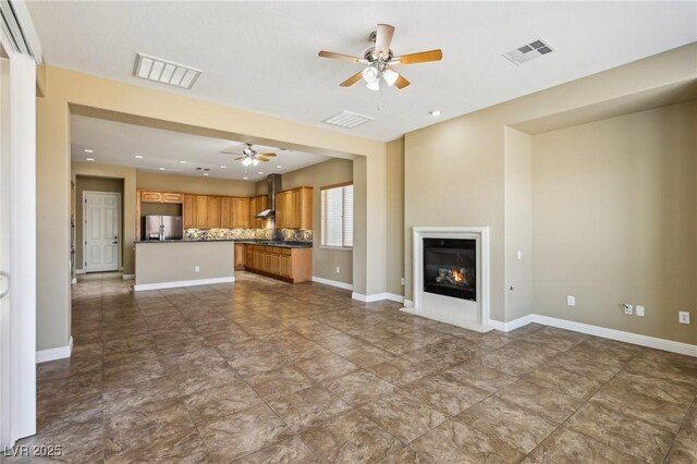 3904 Redbreast Ln, North Las Vegas, NV 89084 - unfurnished living room featuring ceiling fan, baseboards, a glass covered fireplace, and visible vents