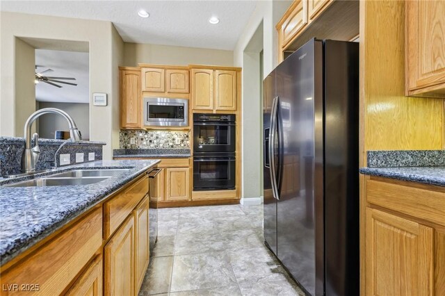 3904 Redbreast Ln, North Las Vegas, NV 89084 - kitchen featuring dark stone countertops, backsplash, a sink, appliances with stainless steel finishes, and ceiling fan