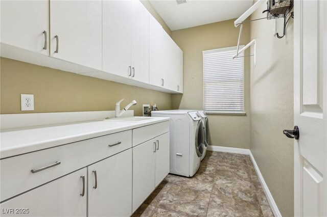 3904 Redbreast Ln, North Las Vegas, NV 89084 - washroom featuring a sink, baseboards, separate washer and dryer, stone finish floor, and cabinet space