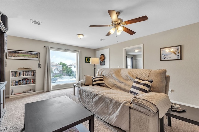 carpeted living area with ceiling fan, baseboards, and visible vents