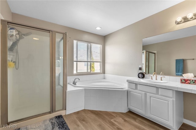 full bathroom featuring vanity, a garden tub, wood finished floors, and a shower stall