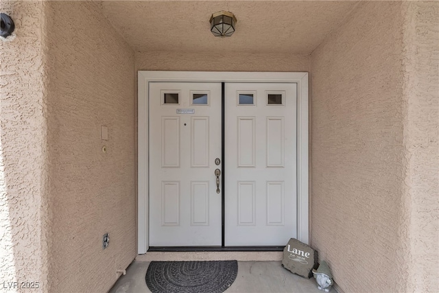 view of exterior entry featuring stucco siding