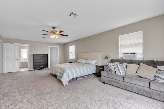 carpeted bedroom featuring cooling unit, multiple windows, and visible vents