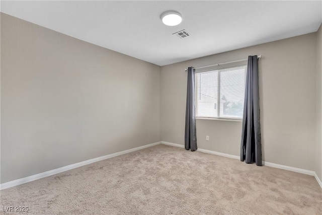 carpeted spare room featuring baseboards and visible vents