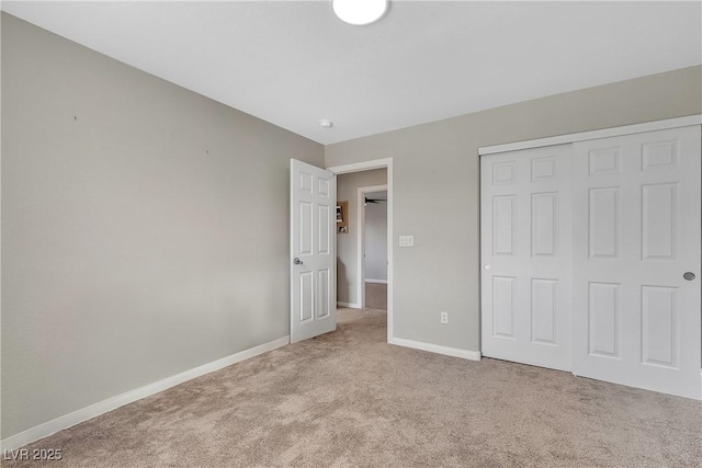 unfurnished bedroom featuring a closet, carpet flooring, and baseboards