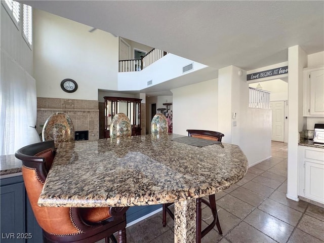1105 Enderly Ln, Las Vegas, NV 89144 - dining room featuring a fireplace, a high ceiling, and baseboards