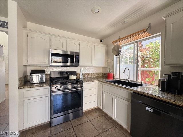 1105 Enderly Ln, Las Vegas, NV 89144 - kitchen featuring appliances with stainless steel finishes, a sink, dark stone countertops, and white cabinetry