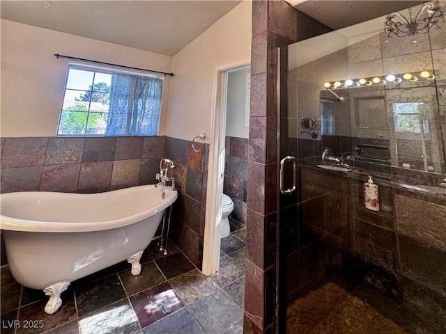 1105 Enderly Ln, Las Vegas, NV 89144 - bathroom featuring tile walls, a shower stall, vaulted ceiling, toilet, and a soaking tub