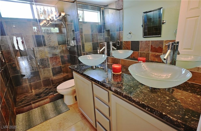 1105 Enderly Ln, Las Vegas, NV 89144 - bathroom with tile walls, a shower stall, tile patterned flooring, toilet, and double vanity