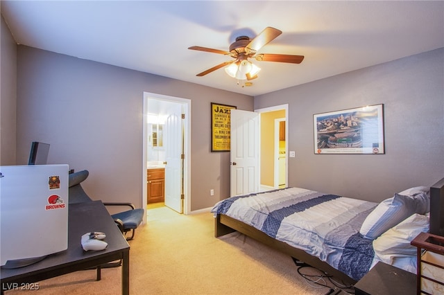 bedroom with baseboards, ceiling fan, light colored carpet, and ensuite bathroom