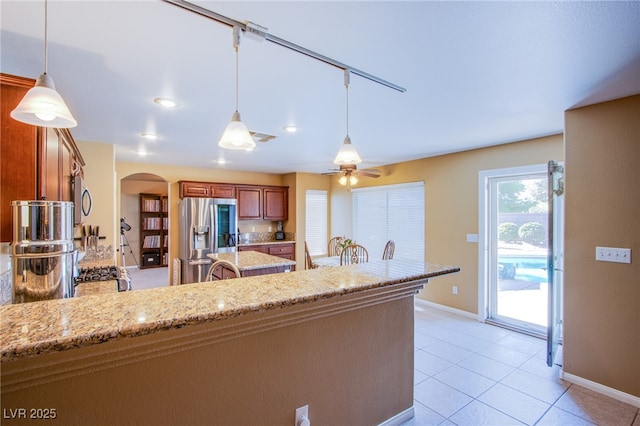 kitchen with visible vents, a peninsula, baseboards, arched walkways, and stainless steel appliances