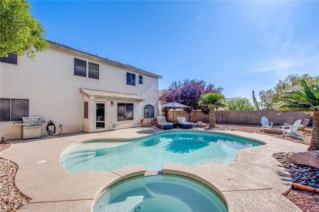 view of swimming pool with a fenced backyard, a patio, a pool with connected hot tub, and a grill