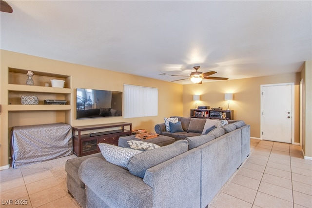 living area with light tile patterned flooring, ceiling fan, and baseboards