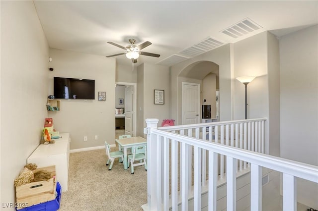 hall featuring visible vents, carpet flooring, baseboards, and arched walkways