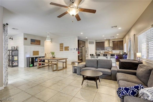 living area featuring visible vents, ceiling fan, and light tile patterned flooring