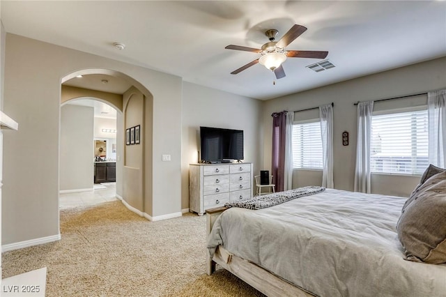 bedroom featuring carpet flooring, ceiling fan, arched walkways, baseboards, and visible vents