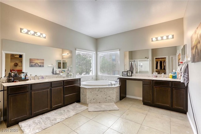 full bath with a bath, tile patterned flooring, a shower stall, two vanities, and a sink