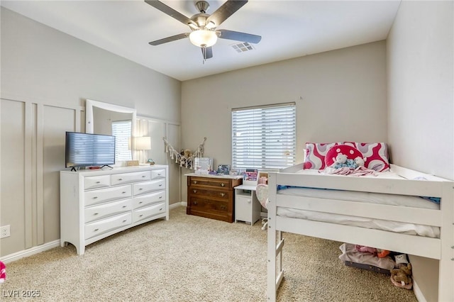 bedroom with visible vents, a ceiling fan, and light colored carpet