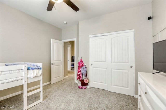 bedroom featuring ceiling fan, light carpet, and a closet