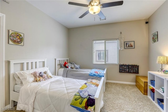 carpeted bedroom with baseboards, a ceiling fan, and visible vents