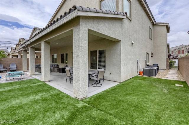 rear view of house with a fenced backyard, a patio area, stucco siding, and a yard