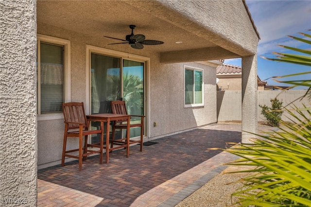 view of patio / terrace with ceiling fan and fence