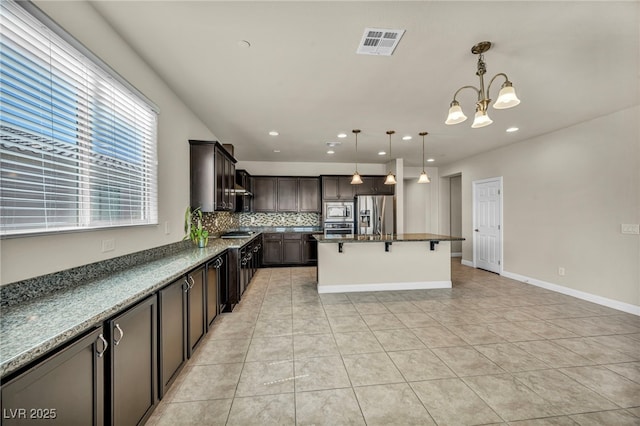 kitchen with an inviting chandelier, visible vents, light tile patterned floors, tasteful backsplash, and appliances with stainless steel finishes