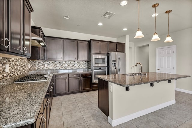 kitchen with tasteful backsplash, visible vents, stainless steel appliances, and a sink