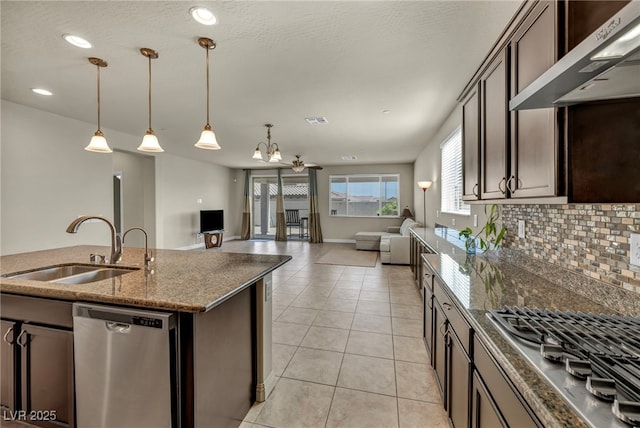 kitchen with dark brown cabinets, extractor fan, a sink, decorative backsplash, and appliances with stainless steel finishes