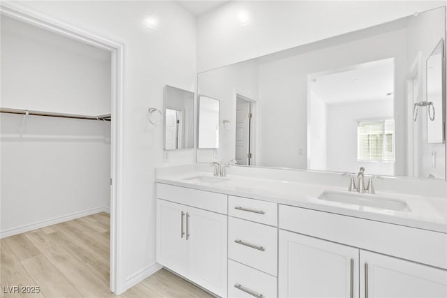 600 N Carriage Hill Dr Unit 2098, Las Vegas, NV 89138 - bathroom featuring a walk in closet, wood finished floors, baseboards, and a sink