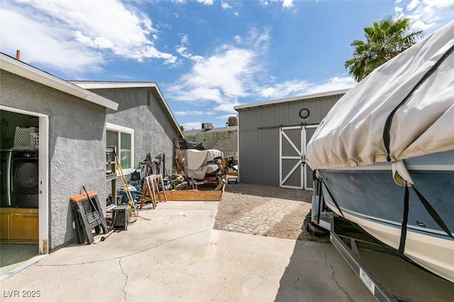 386 Summer Creek Ct, Henderson, NV 89002 - view of patio / terrace featuring a storage shed, an outdoor structure, and washer / clothes dryer
