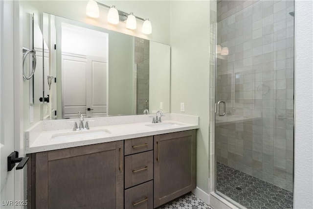 bathroom with double vanity, a stall shower, and a sink
