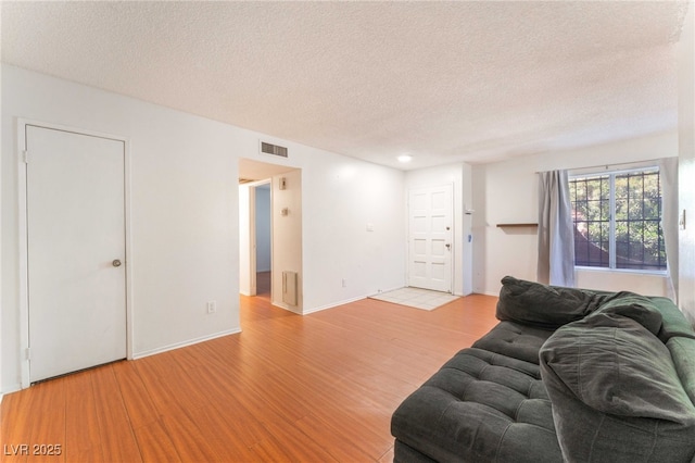 4687 Monterey Cir Unit 1, Las Vegas, NV 89169 - living room with light wood finished floors, baseboards, visible vents, and a textured ceiling