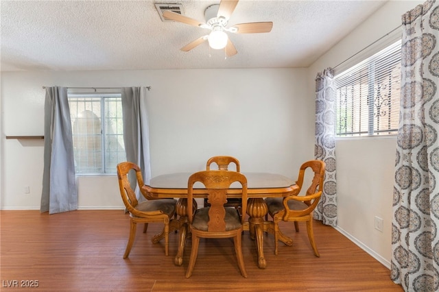4687 Monterey Cir Unit 1, Las Vegas, NV 89169 - dining space featuring a ceiling fan, wood finished floors, a textured ceiling, and visible vents