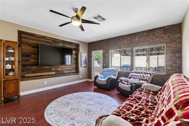 living room featuring baseboards, wood finished floors, visible vents, and ceiling fan