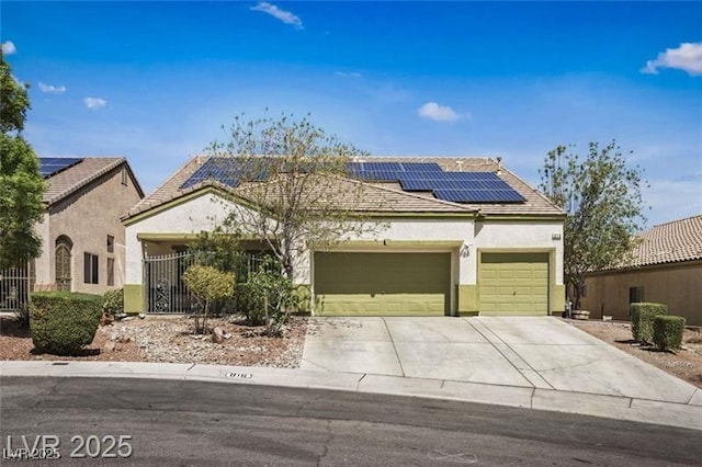 view of front facade with stucco siding, roof mounted solar panels, an attached garage, and concrete driveway